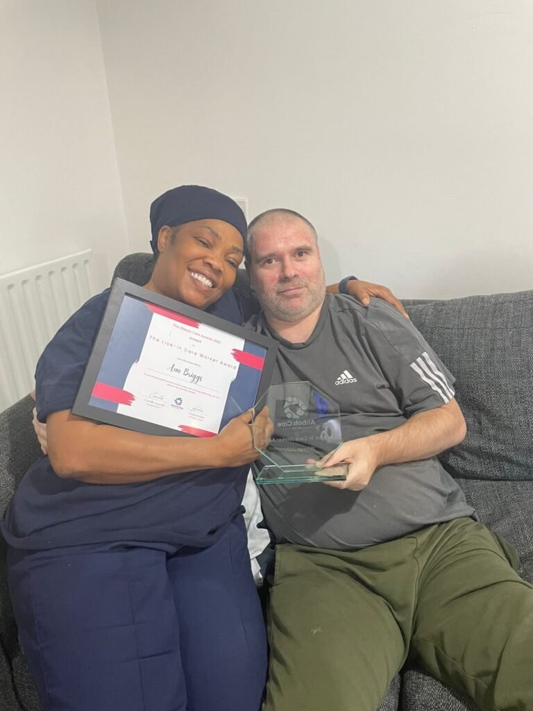 A female care provider with a man celebrating home care provider services at Abbots Care